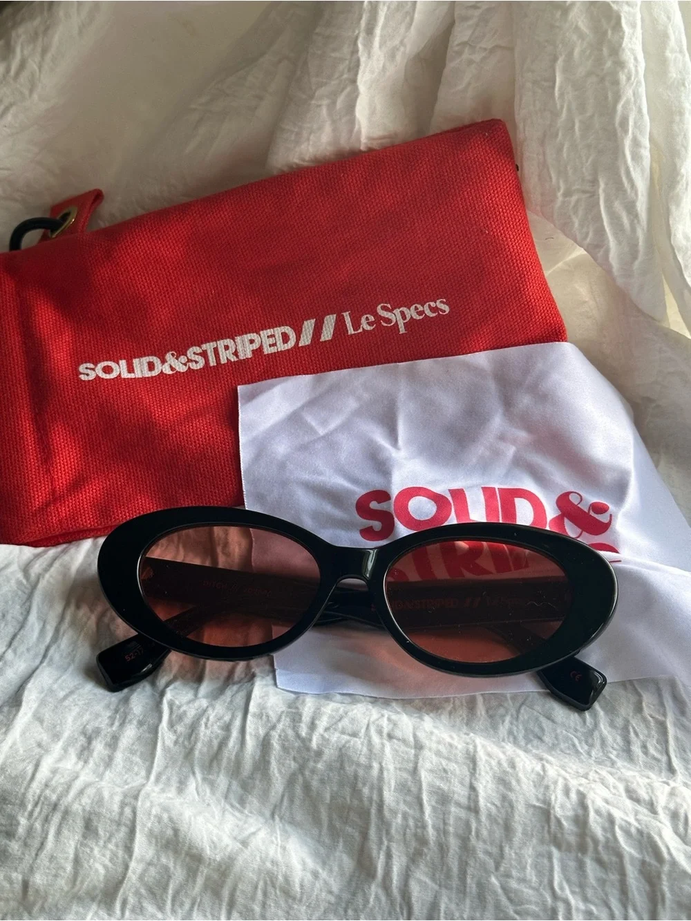 SOLID & STRIPED Black Oval Sunglasses with Red-Tinted Lenses